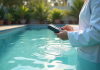 Personne en blouse blanche testant une piscine trouble en extérieur